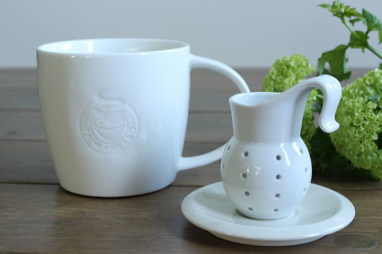 エンボスロゴ入りの白磁マグカップと茶こしのセット